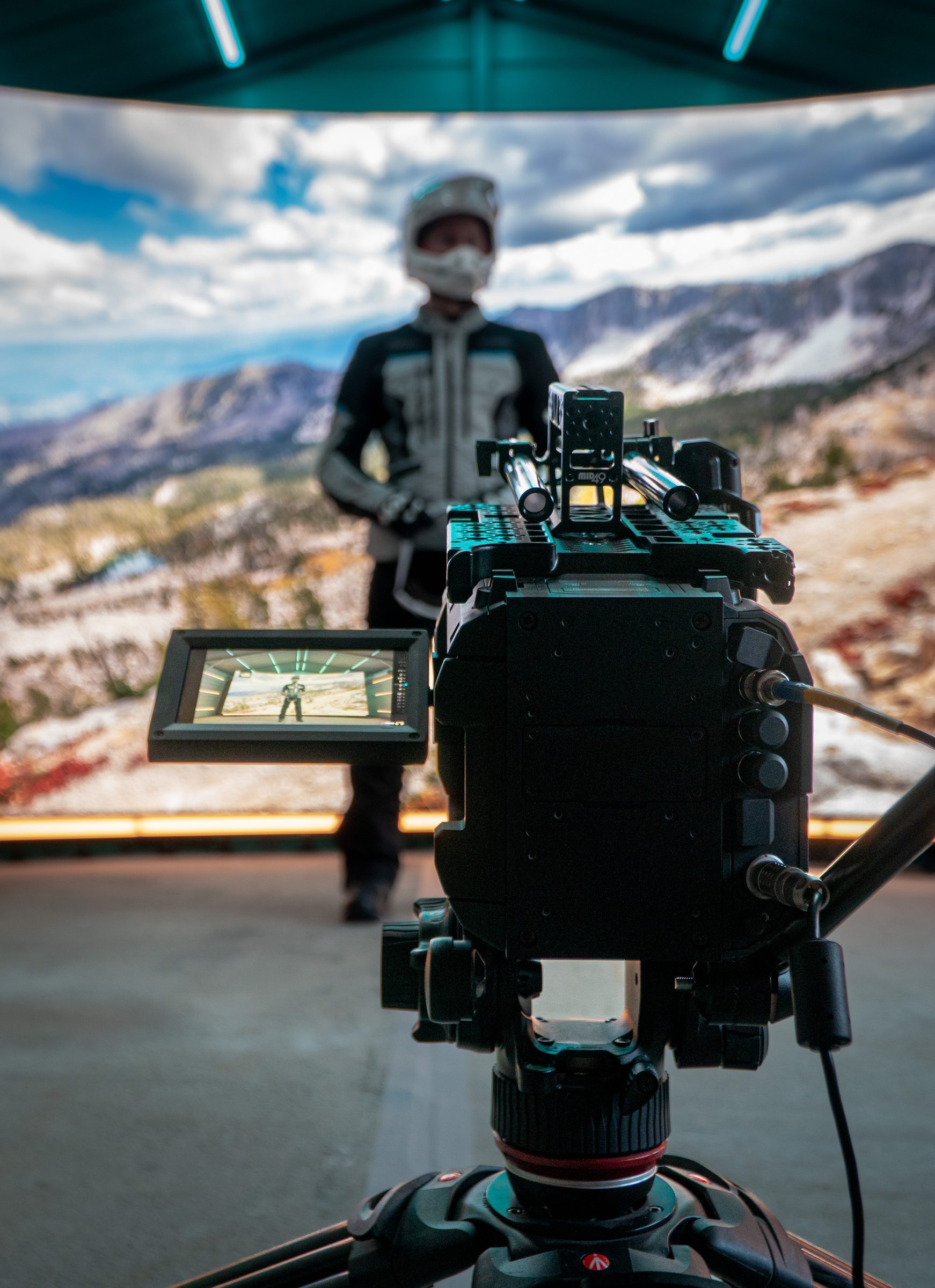Cinema camera on the LED stage with a rider and alpine scene behind it