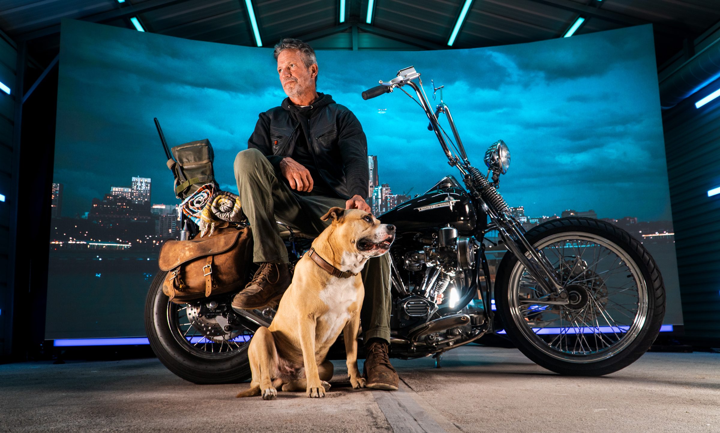 Rider and his dog on a chopper in front of a city skyline on the LED wall