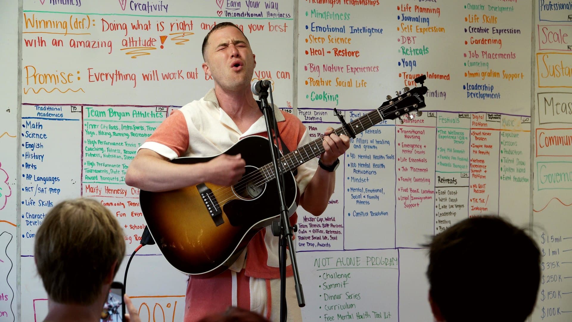 Mike Posner playing acoustic guitar for the foundation's students