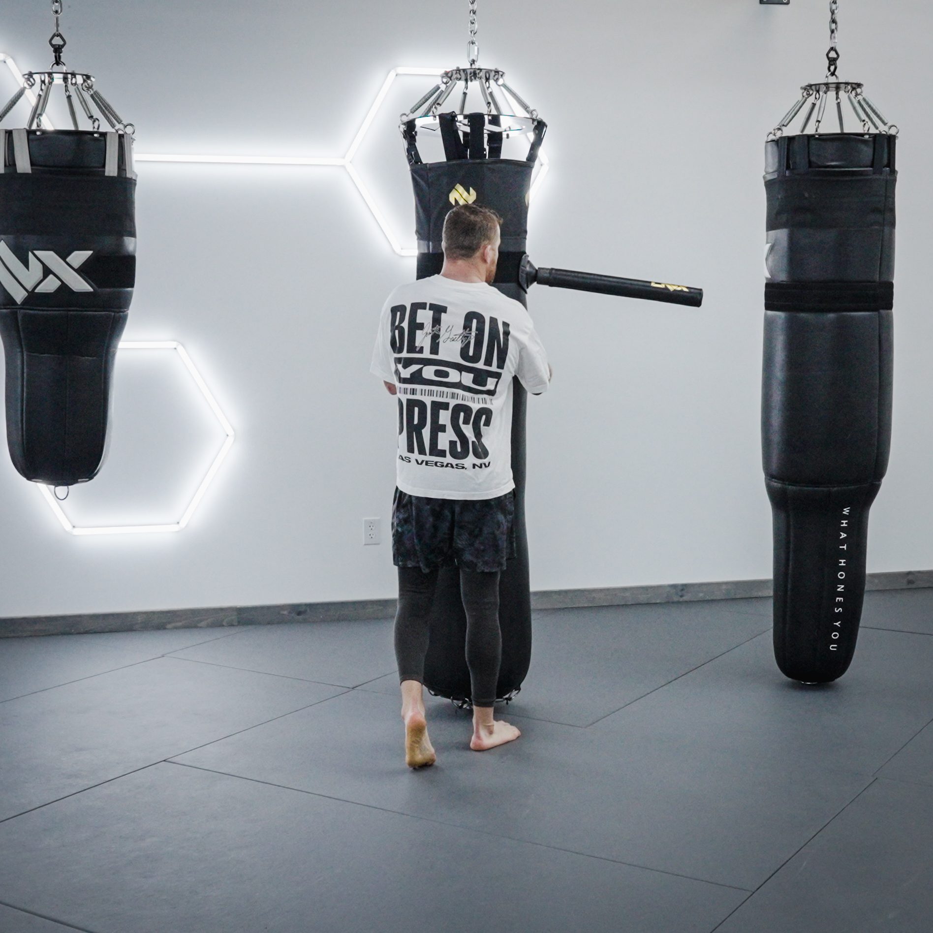 Gaethje walking between heavy bags, "Bet On You" across his back