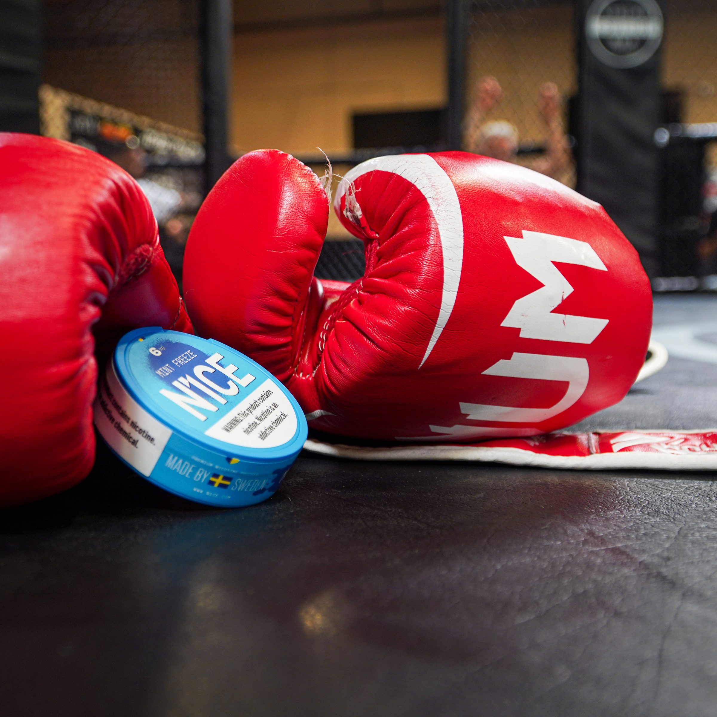 Red boxing gloves and a tin of N1CE on the gym floor