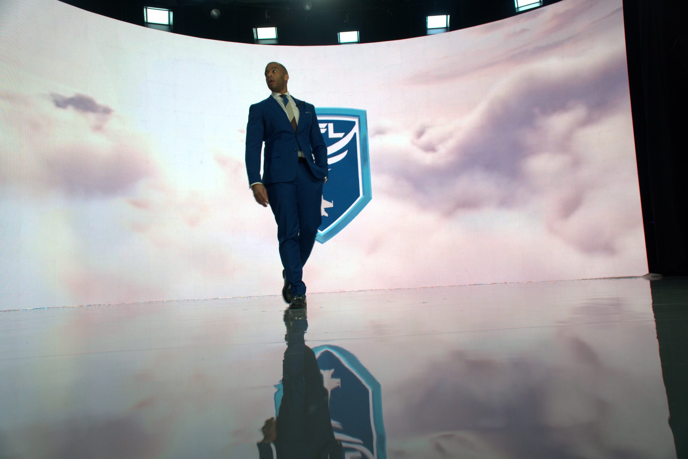 Host walking toward camera across the XR stage