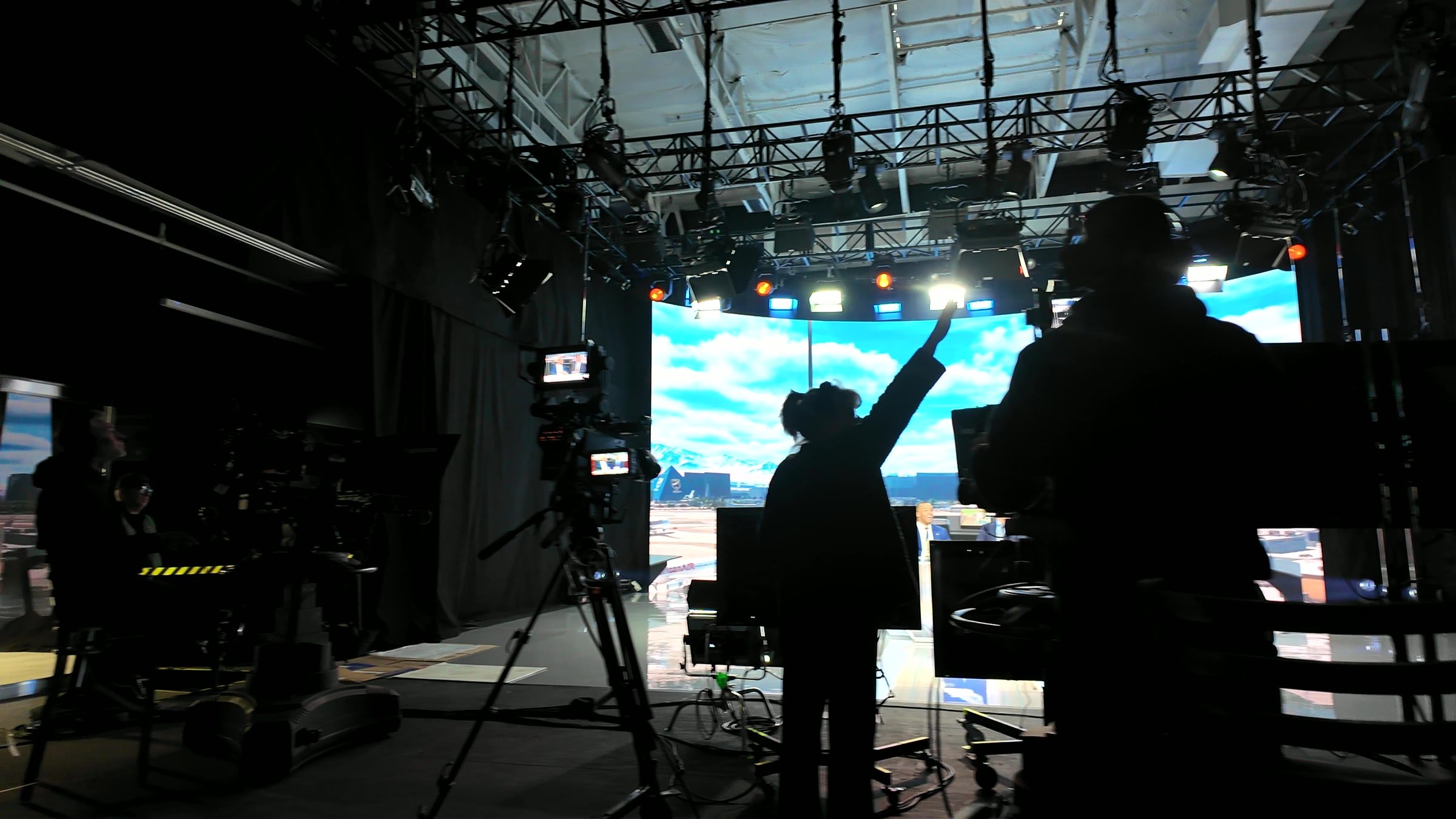 Floor crew in silhouette against the XR wall, cueing the stage