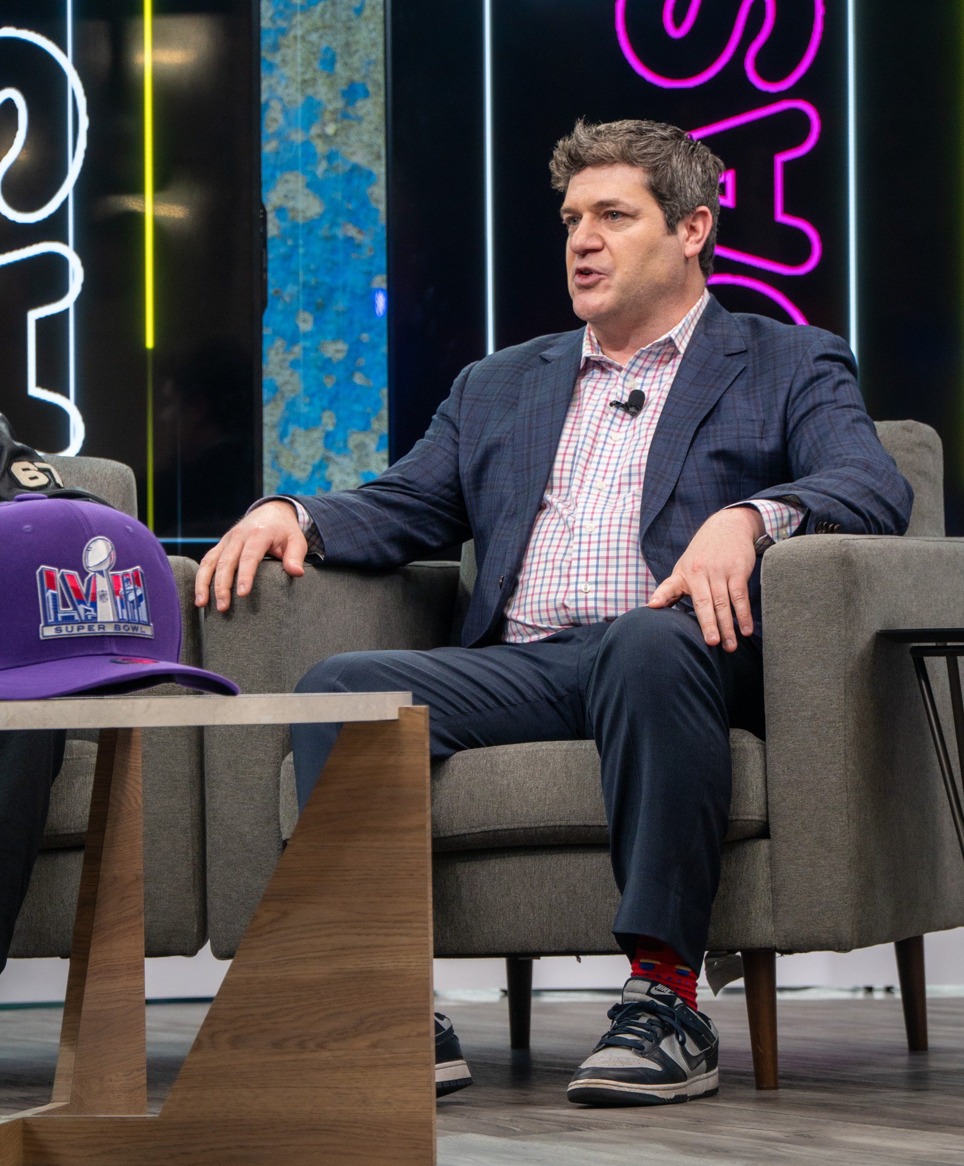 Guest on a purple-lit interview set on Radio Row